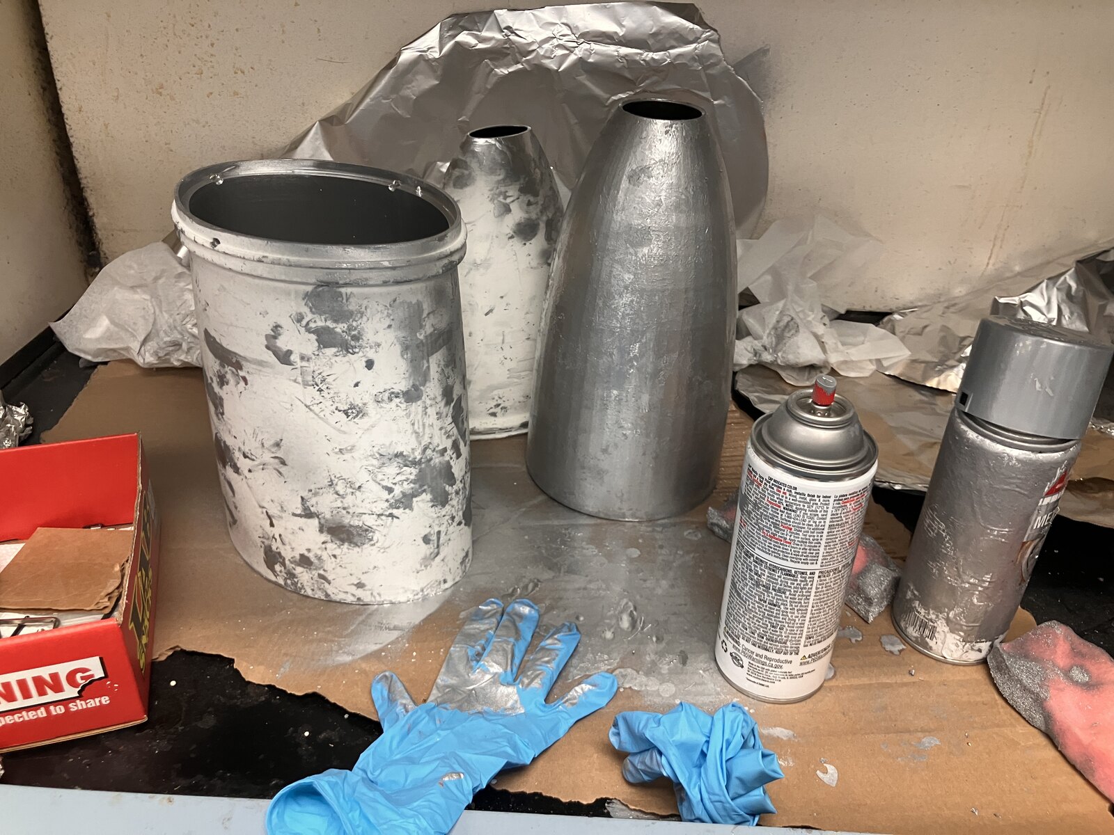 Concentrators being spray-coated, with paint cans and gloves on the bench