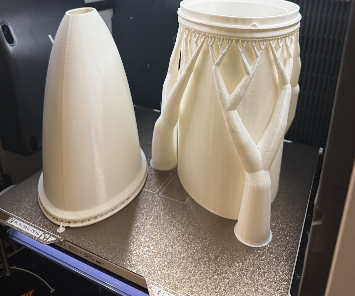 The two 3D-printed concentrators: a single-piece circular CPC beside the two-part elliptical design