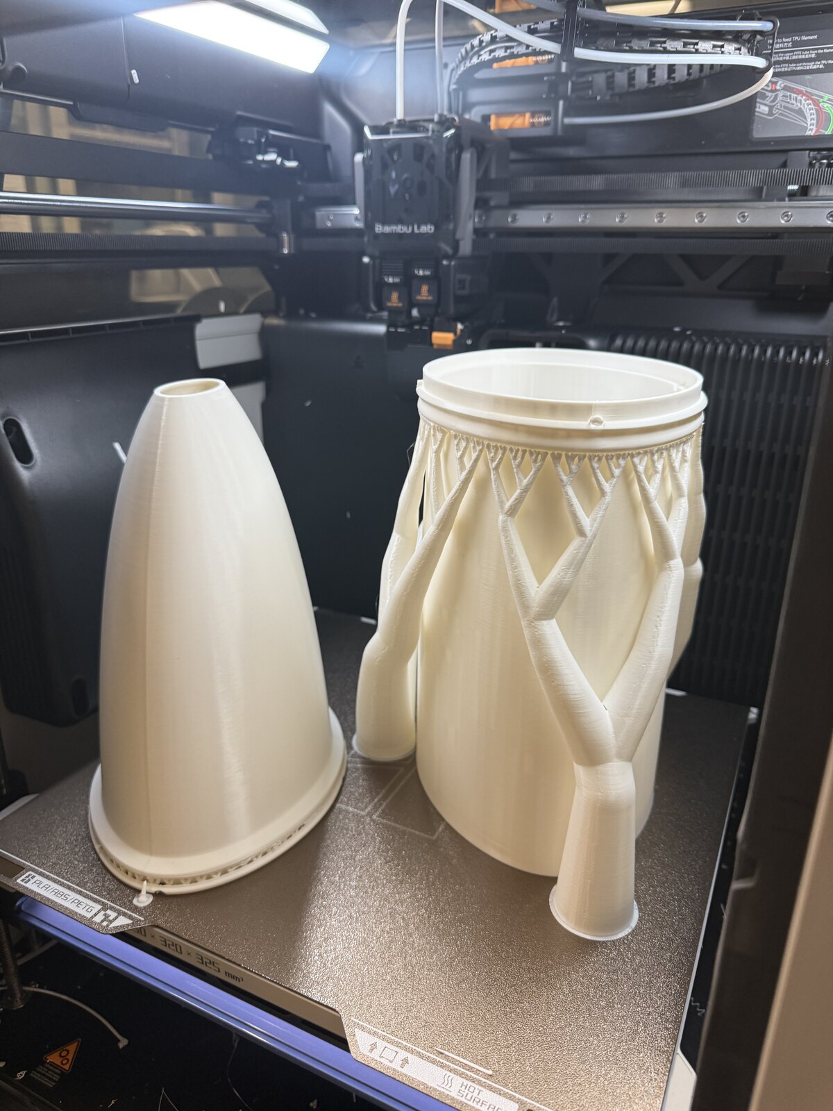 Two 3D-printed concentrators: a single-piece circular cone and a segmented two-part elliptical design